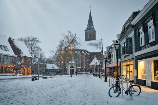Sneeuw in Alkmaar rond het Waagplein met natte straat en winterse lucht